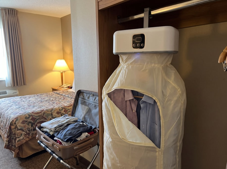 The dryer hung in a hotel wardrobe beside an open suitcase